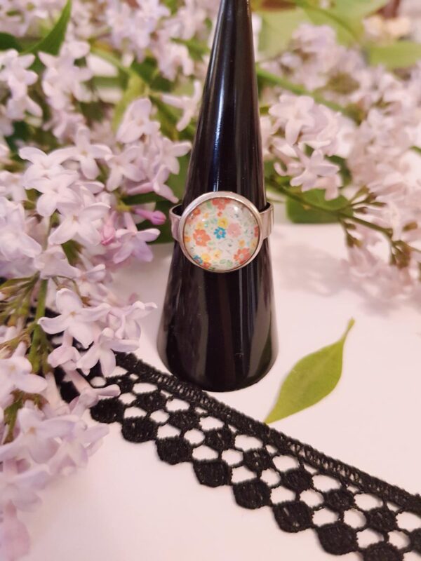 Bague inox - cabochon fleurs multicolores pastel sur fond blanc