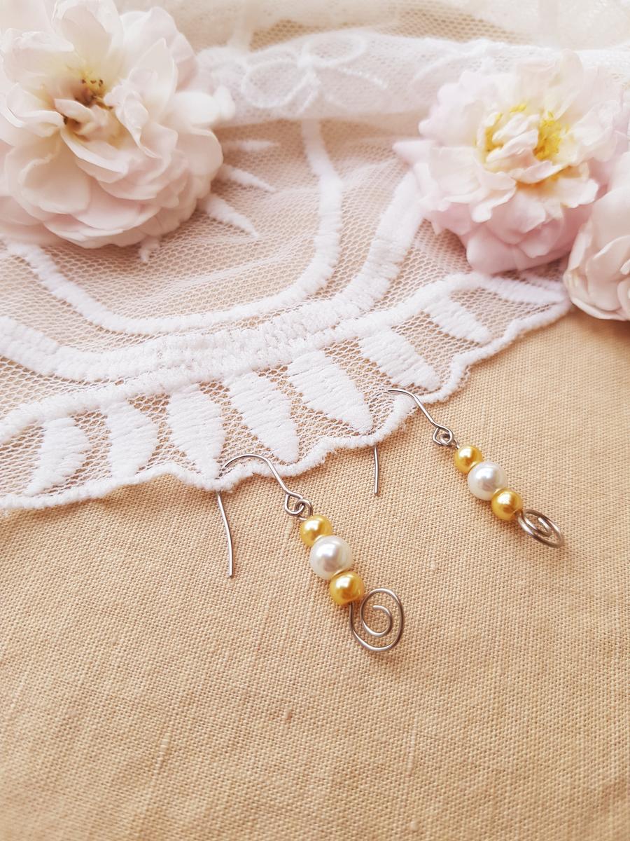 Boucles doreille inox mariage fait main - Arabesque et perles blanches et doré clair. Calino Crea Boucles doreille inox mariage fait main - Arabesque et perles blanches et doré clair. Calino Crea