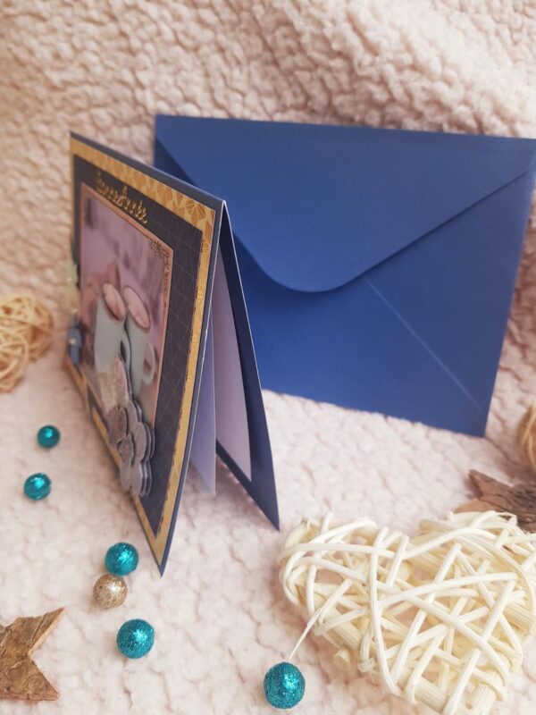 Carte artisanale “Bonne année” bleue et dorée avec des tasses et des fleurs. Calino Créa