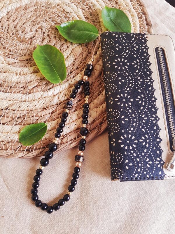 Attache / bijou pour portable artisanal - perles noires et dorées. Calino Créa