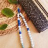 Attache / bijou pour portable artisanal - perles turquoises et bleues. Calino Créa