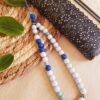 Attache / bijou pour portable artisanal - perles turquoises et bleues. Calino Créa