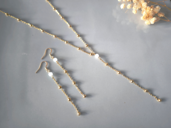 22865 - Parure pierre naturelle et chaine perlee Parure composée de boucles d'oreilles et collier avec une pierre naturelle jade blanc et chaine à billes en acier inoxydable doré